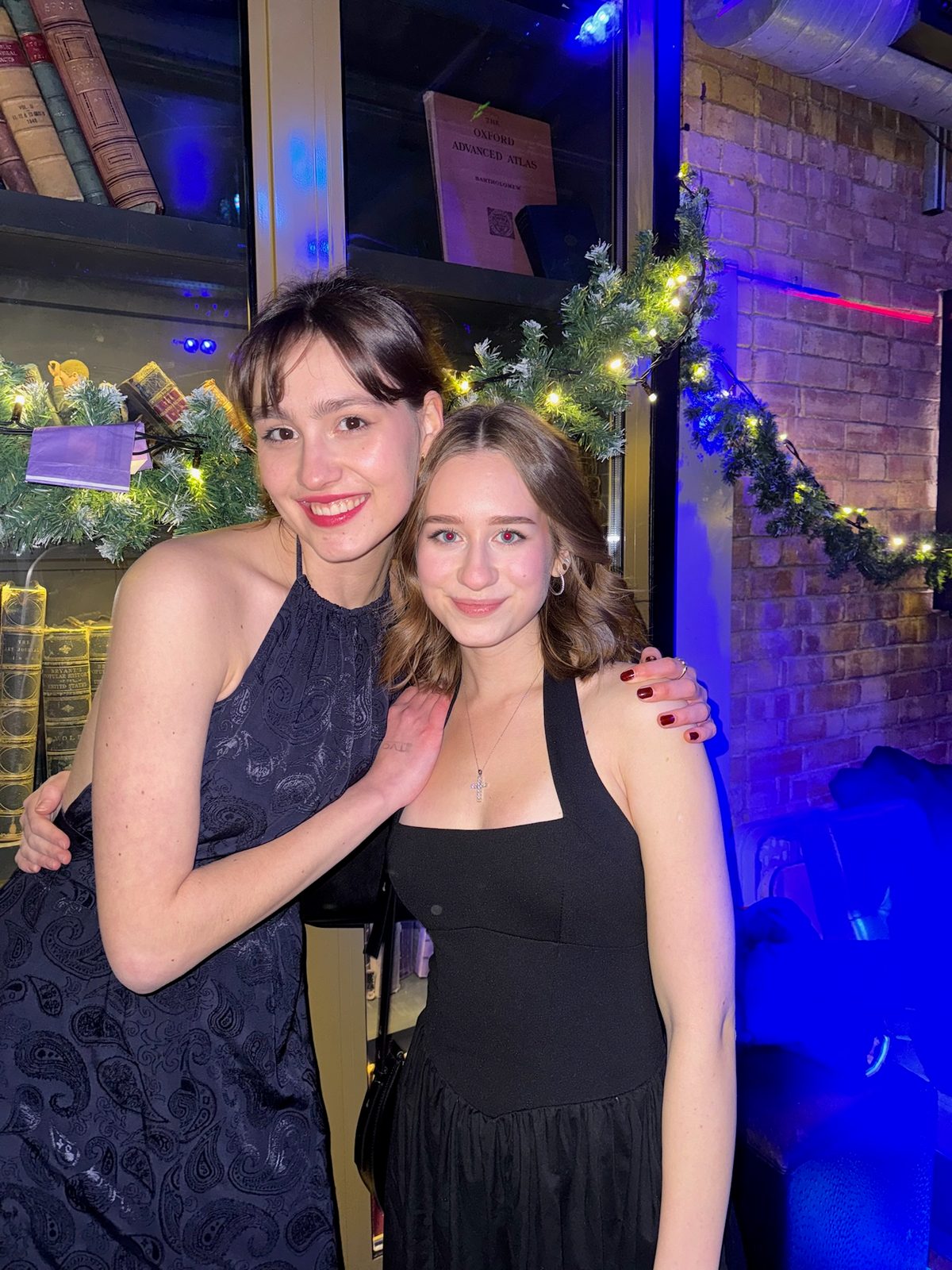 Two people posing together beside festive decorations