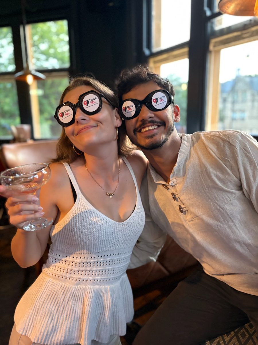 Two people smiling in Date IRL glasses