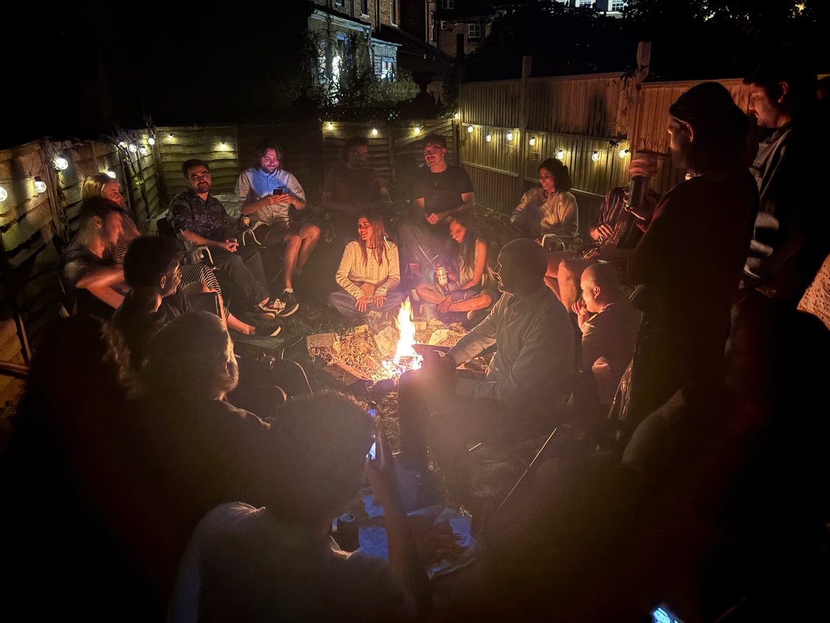 People gathered around a fire outdoors at night
