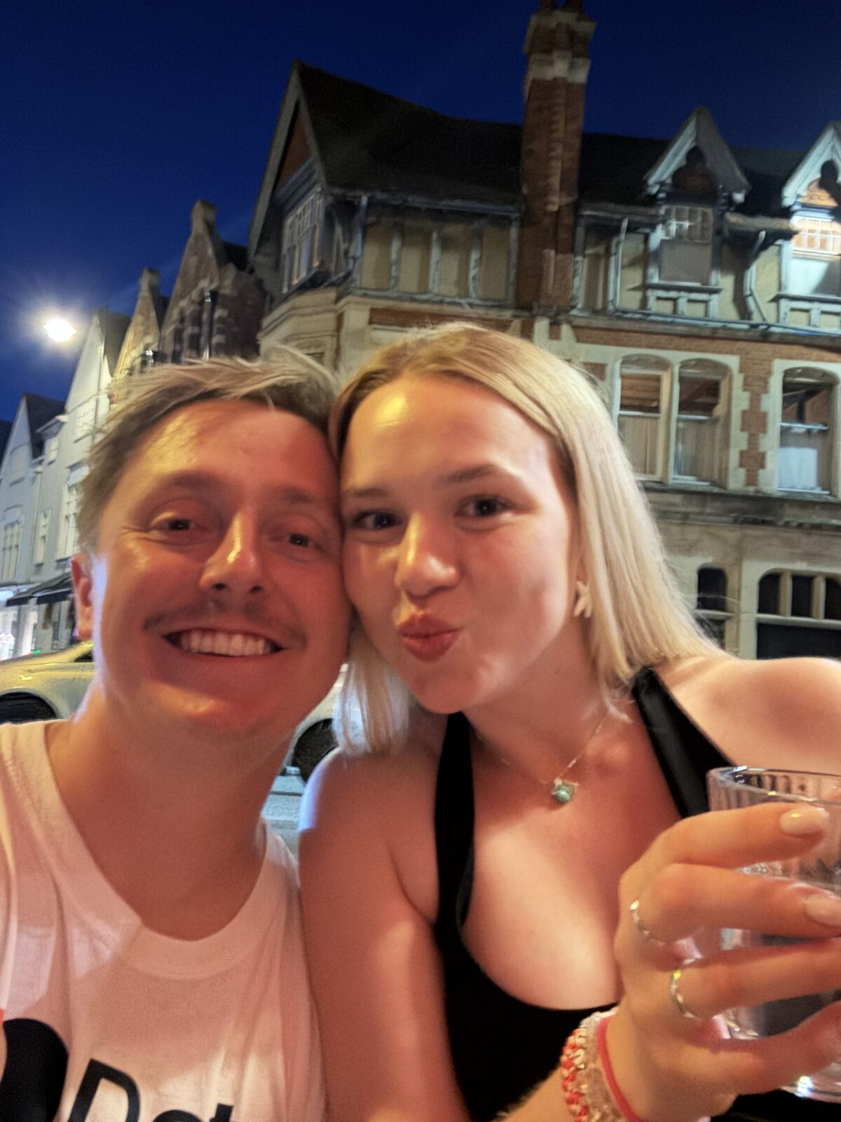 Two people posing together outdoors at night