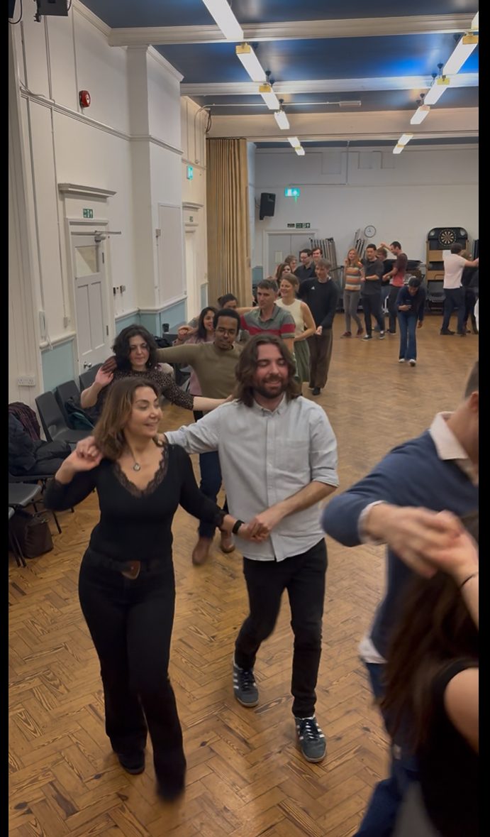 People dancing together in lines at a ceilidh