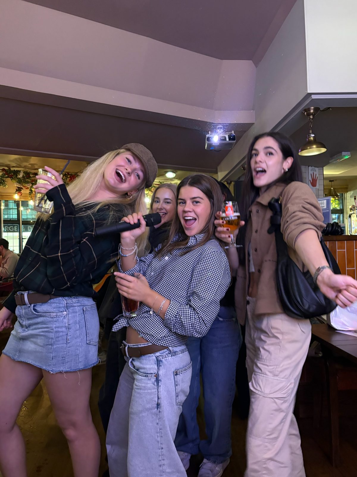 Four people singing together at karaoke